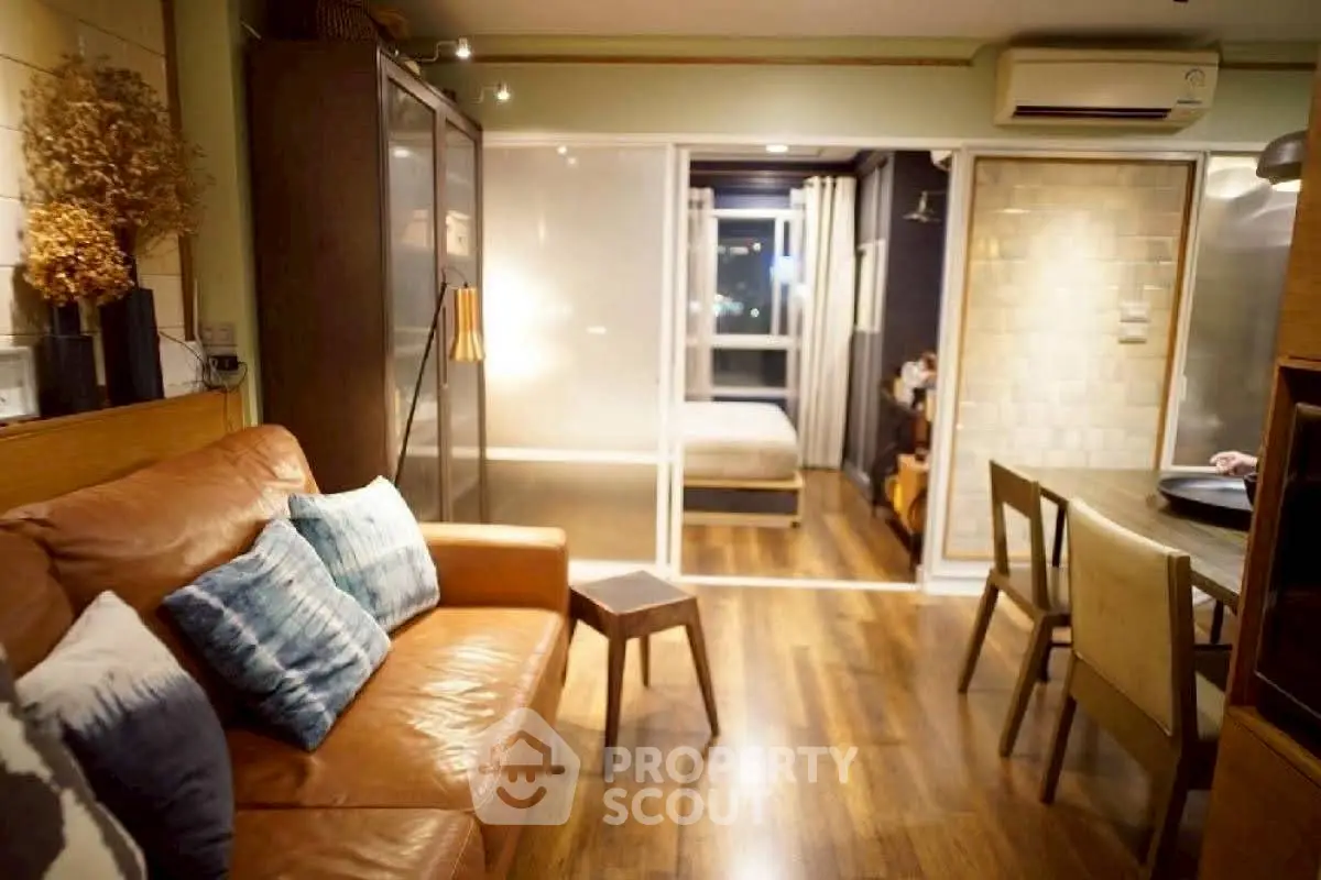 Cozy living room with leather sofa and dining area in modern apartment