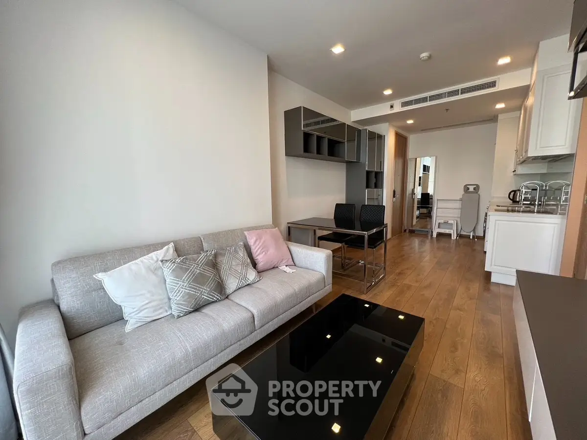 Modern living room with sleek furniture and wooden flooring in a stylish apartment.