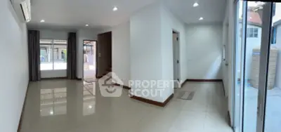 Spacious and well-lit living area with glossy tiled flooring, multiple entryways, and a versatile layout perfect for customization in a modern home.