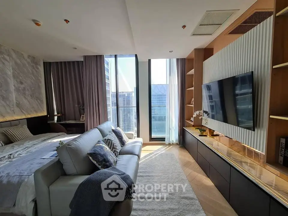 Luxurious modern living room with large windows and elegant decor in a high-rise apartment.