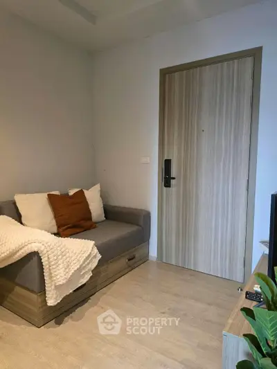 Cozy living room with modern sofa and wooden flooring, perfect for relaxation.