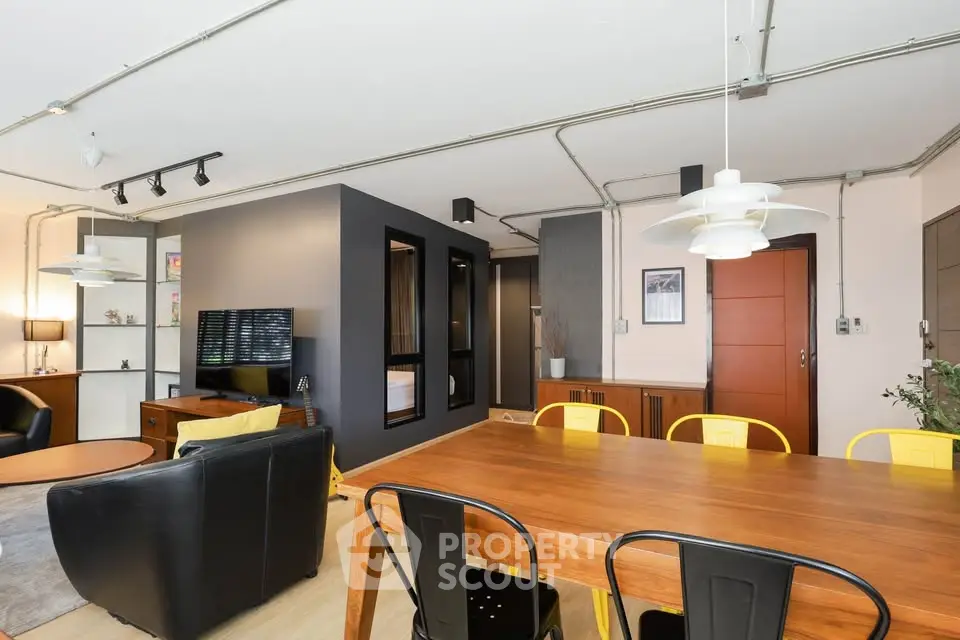 Modern open-concept living and dining area with stylish furniture and industrial design.