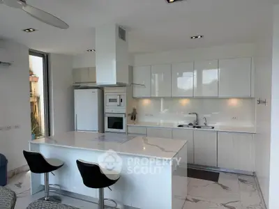 Modern kitchen with sleek white cabinetry and marble island in a contemporary home.