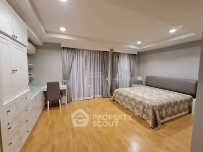 Spacious bedroom with elegant decor and ample natural light