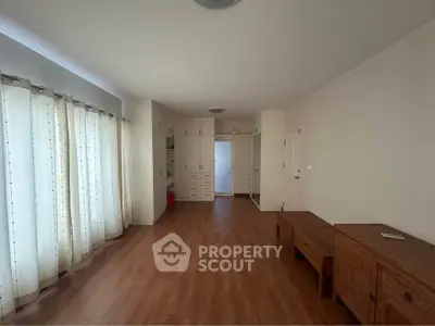 Spacious living room with wooden flooring and ample natural light