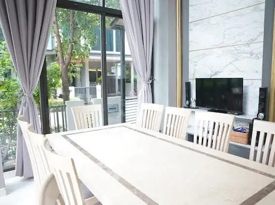 Elegant dining area with large windows and modern decor, perfect for family gatherings.