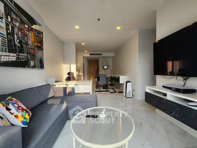 Modern living room with sleek decor, large TV, and stylish furniture in a contemporary apartment.