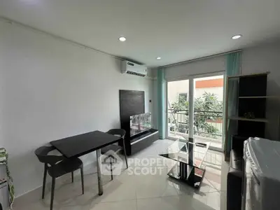 Modern living room with sleek furniture and balcony access, perfect for urban living.