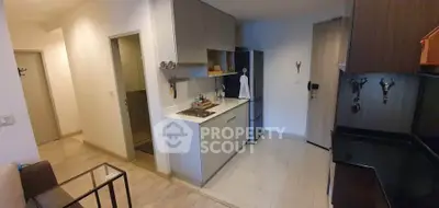 Modern kitchen with sleek cabinetry and integrated appliances in a cozy apartment setting.