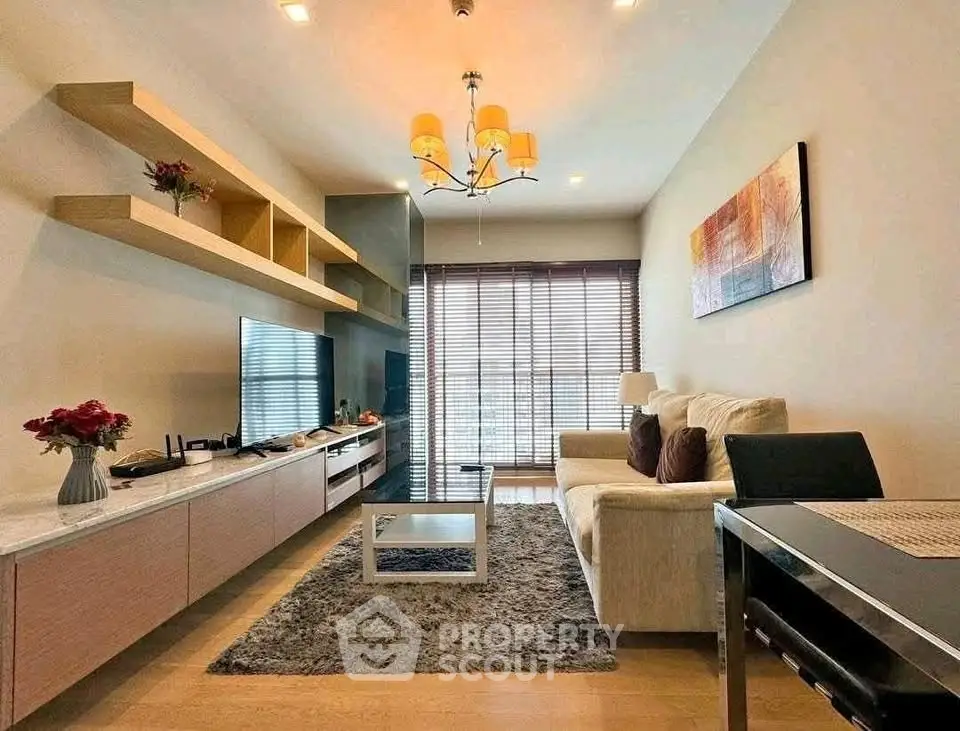 Modern living room with stylish decor, cozy seating, and natural light from large windows.
