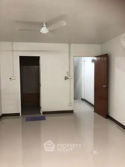 Spacious interior with ceiling fan and open doorways, ideal for customization.