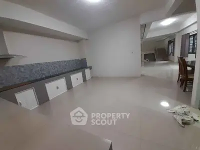 Spacious open-plan living area with tiled flooring and modern design