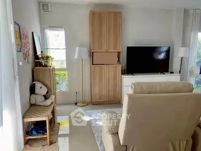 Cozy living room with modern decor and large TV, perfect for relaxation.