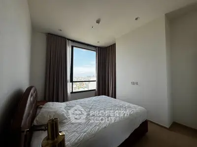 Cozy bedroom with city view, featuring a comfortable bed and large window for natural light.