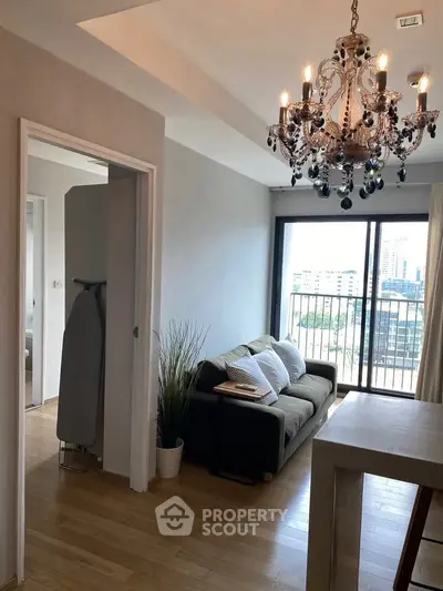 Chic living room with chandelier and city view balcony in modern apartment