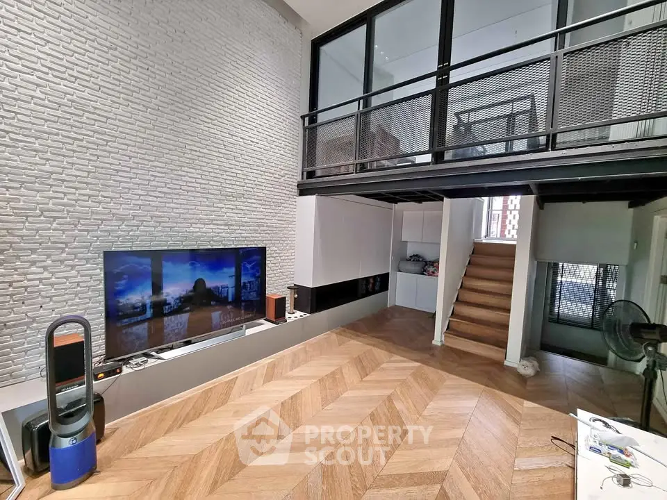 Modern loft-style living room with mezzanine, sleek decor, and stylish wood flooring.