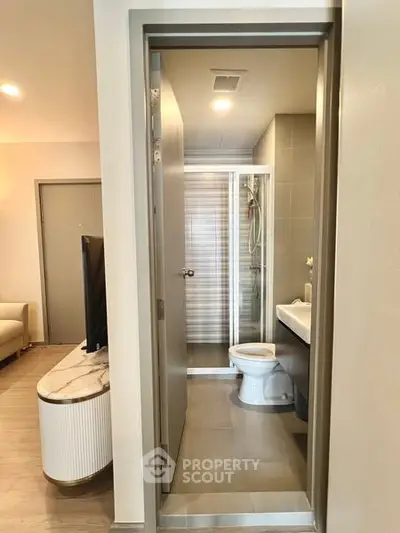 Modern apartment bathroom with sleek design and adjacent living area