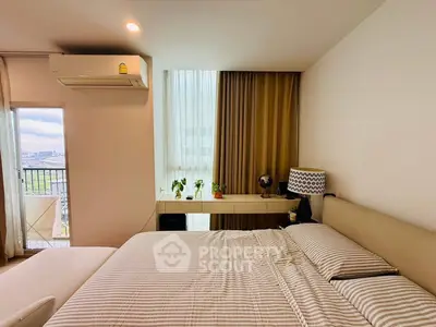 Modern bedroom with balcony view and stylish decor in urban apartment.