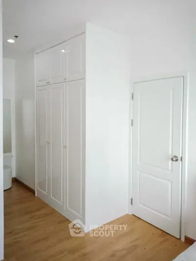 Modern white wardrobe with wooden flooring in a bright room
