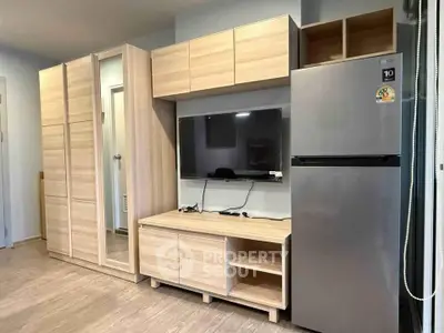 Modern living room with sleek wooden furniture and stainless steel fridge