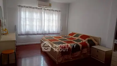 Spacious bedroom with large window and cozy bed in modern apartment.