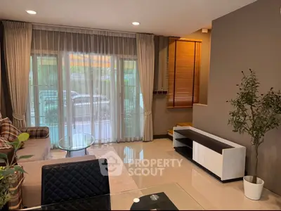 Spacious living room with large windows and modern decor in a stylish home.