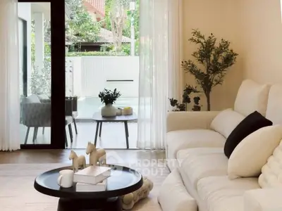 Elegant living room with plush sofa and garden view, perfect for relaxation and entertaining.