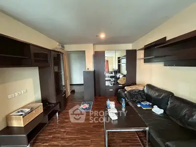 Spacious living room with modern furniture and wooden flooring in a stylish apartment.
