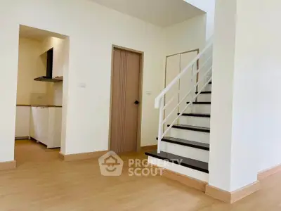 Modern interior with wooden flooring, staircase, and open kitchen layout in a bright, spacious home.