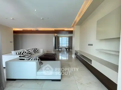 Luxurious modern living room with elegant white sofas and marble flooring, offering a spacious and stylish ambiance.
