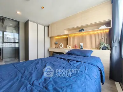 Modern bedroom with stylish wood paneling and cozy blue bedding in a bright apartment.