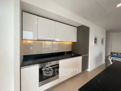 Modern kitchen with sleek cabinetry and built-in oven in a stylish apartment.