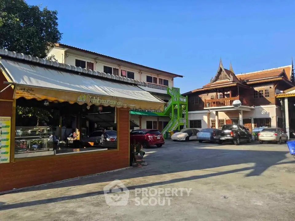 Charming traditional and modern buildings with parking area under clear blue sky.
