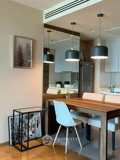Modern dining area with stylish pendant lights and wooden table in contemporary apartment.