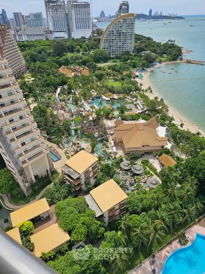 Stunning aerial view of luxury beachfront resort with lush gardens and ocean backdrop.