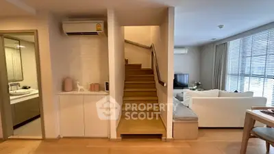 Modern duplex apartment with open living area and stylish staircase