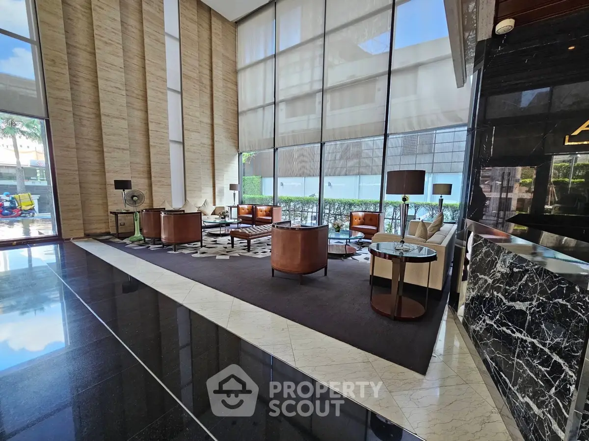 Luxurious modern lobby with high ceilings and elegant furnishings in a prestigious building.