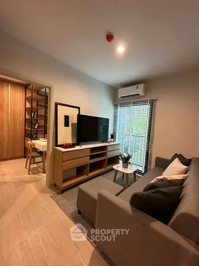 Modern living room with stylish furniture and natural light, featuring a cozy sofa and entertainment center.