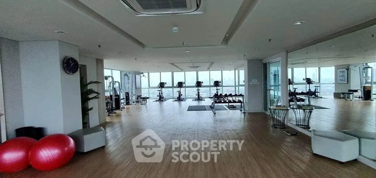 Spacious gym with modern equipment and panoramic windows offering stunning views.
