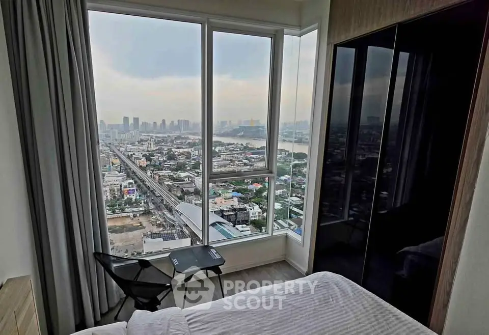 Stunning high-rise bedroom with panoramic city view and modern furnishings.