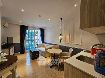 Charming living room with elegant decor and natural light, featuring cozy seating and modern kitchenette.