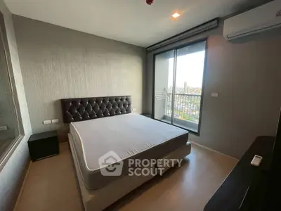 Modern bedroom with large window and city view, featuring a comfortable bed and air conditioning.
