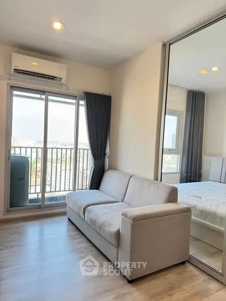 Modern living room with balcony view and mirrored closet in a stylish apartment.