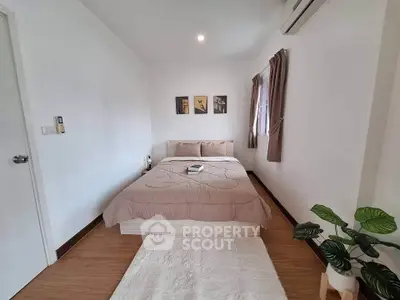 Cozy bedroom with modern decor and natural light, perfect for relaxation.