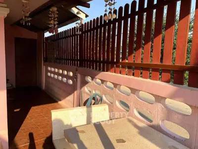 Charming balcony with rustic wooden fence and cozy seating area, perfect for relaxation.