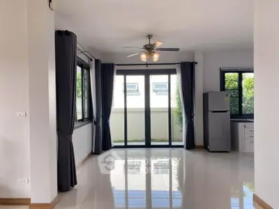 Spacious living room with large windows and modern ceiling fan