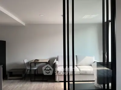 Modern living room with sleek glass partition and cozy furniture