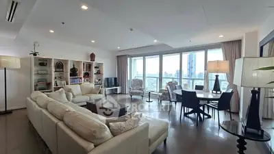Spacious modern living room with large windows and city view, perfect for entertaining.