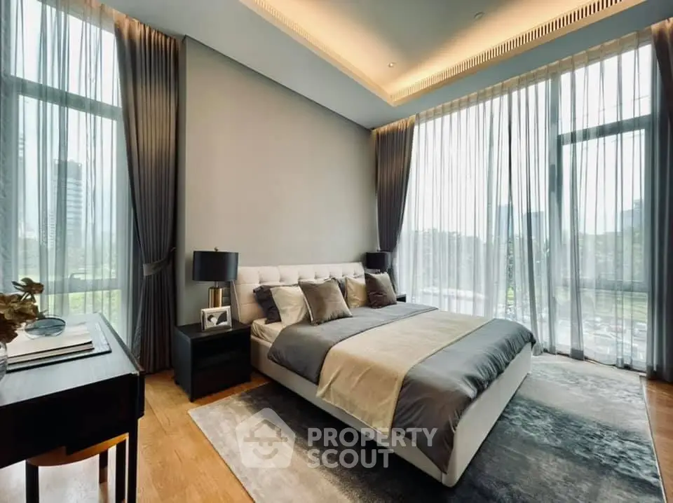 Luxurious bedroom with floor-to-ceiling windows and elegant decor in a modern apartment.