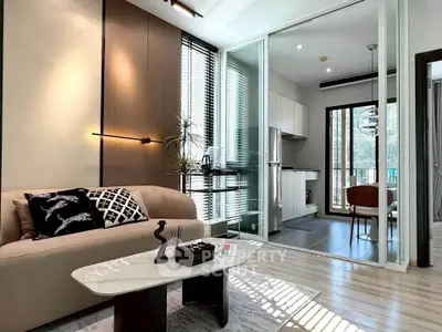 Modern living room with stylish decor and open kitchen layout, featuring natural light and contemporary design.